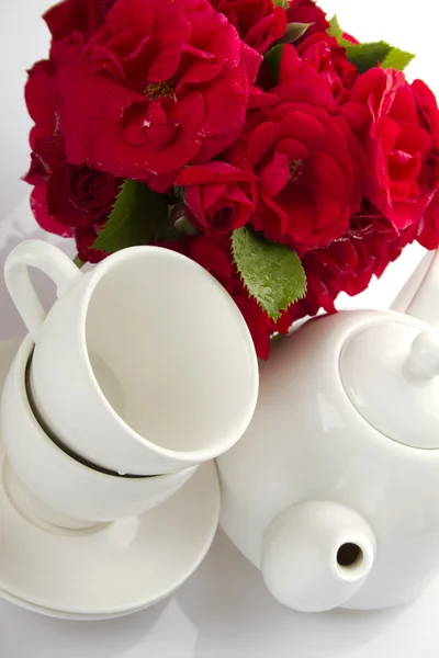 Weißes Geschirr für Tee und ein Strauß Rosen — Stockfoto