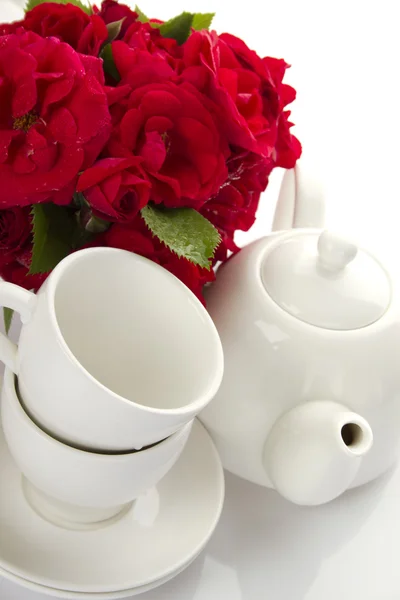 Vaisselle blanche pour le thé et un bouquet de roses — Photo