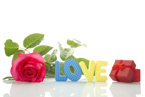Czerwona róża, pudełko i tekst "miłość" — Zdjęcie stockowe