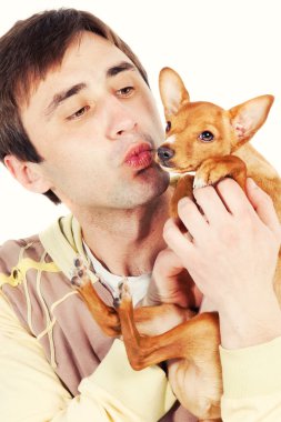 Man kising a small pincher puppy clipart