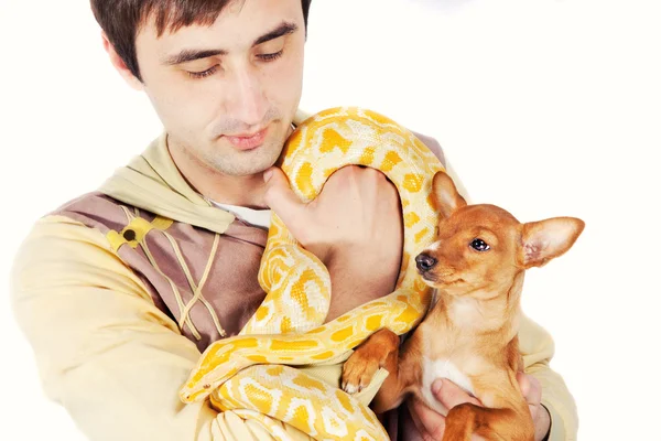 Un uomo che tiene in braccio i suoi animali domestici pitone e un cucciolo — Foto Stock