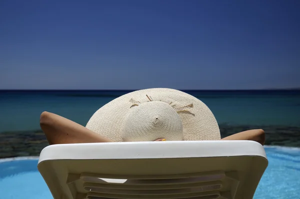 在休息的海域上空一顶帽子的女人 — 图库照片
