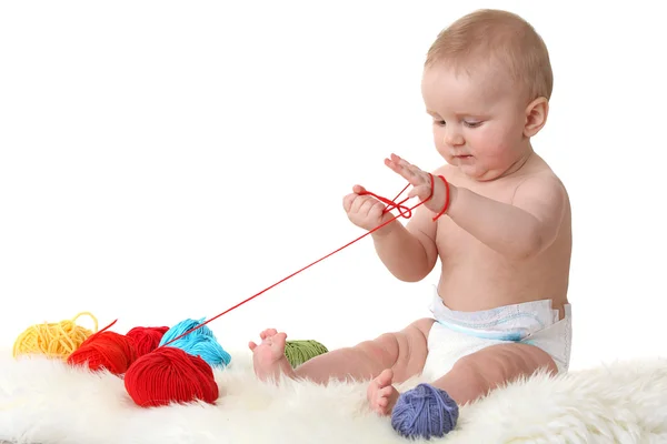 Pequeño bebé con bolas de lana — Foto de Stock