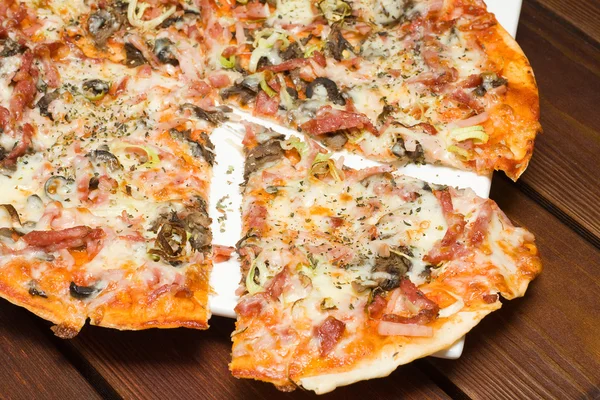 Italian pizza on wooden table in restaurant — Zdjęcie stockowe