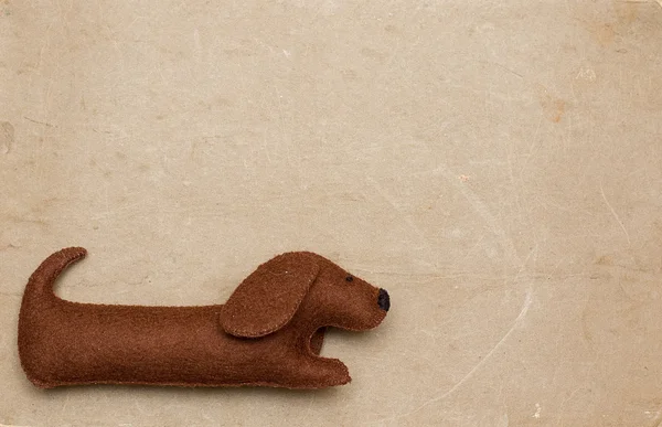 Mainan anjing pada latar belakang kertas lama — Stok Foto