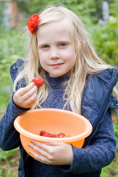Mooi meisje met rode aardbei in tuin — Stockfoto