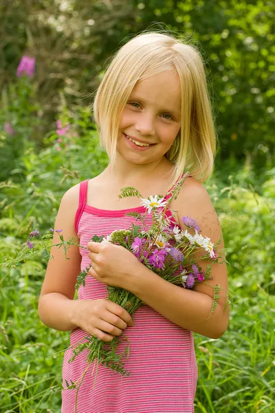 屋外の花と笑顔の女の子 — ストック写真