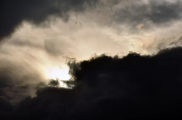 Бледный свет сквозь черные облака — стоковое фото