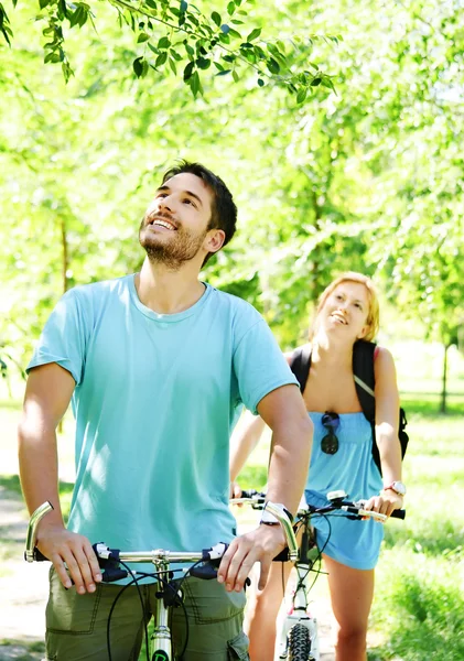 年轻快乐的夫妻骑着一辆自行车 — 图库照片