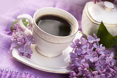 Porcelain cup with coffee and lilac clipart