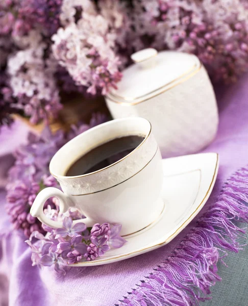 Copo de porcelana com café e lilás — Fotografia de Stock