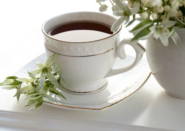 Liljekonvalj och en kopp kaffe — Stockfoto