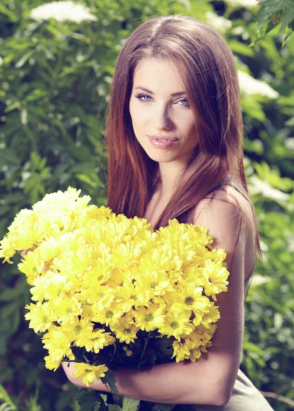 Frau mit gelben Blumen. Dreharbeiten vor der Tür — Stockfoto