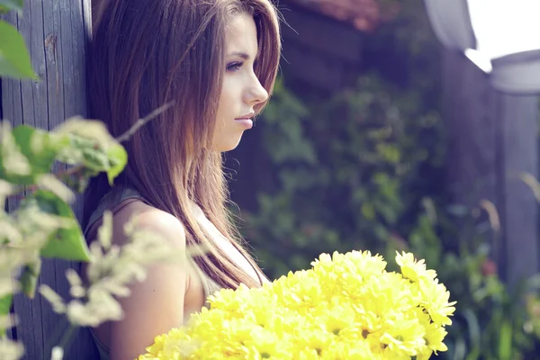 Frau mit gelben Blumen. Dreharbeiten vor der Tür — Stockfoto