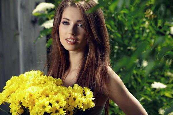 .Bahçe içinde güzel kadın rahatlatıcı. sarı çiçek tutan — Stok fotoğraf