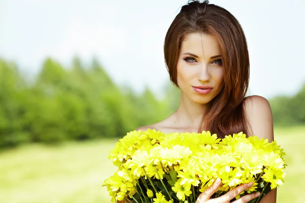 黄色の花が笑みを浮かべてかわいい若い女の子のクローズ アップの肖像画 — ストック写真