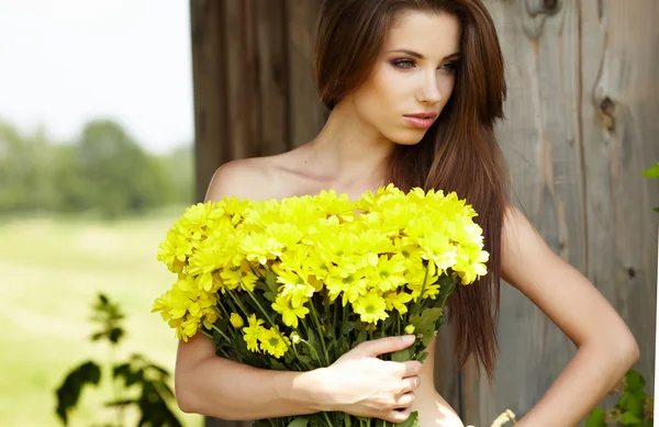 Closeup portret van schattig jong meisje met gele bloemen glimlachen — Stockfoto