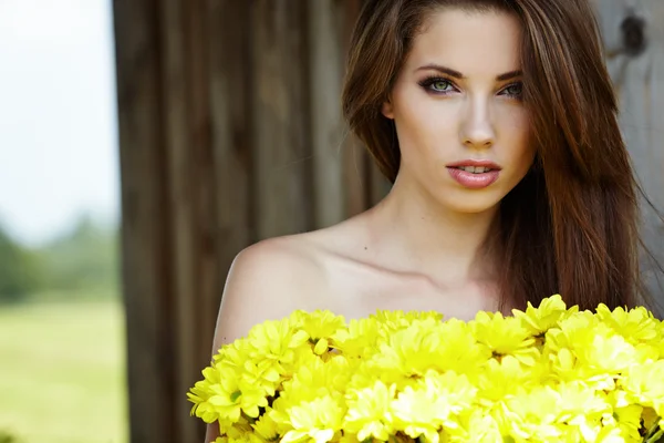 Primer plano retrato de linda joven con flores amarillas sonriendo — Foto de Stock
