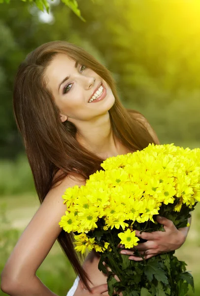 Νεαρή γυναίκα εκμετάλλευση κίτρινα λουλούδια — Φωτογραφία Αρχείου