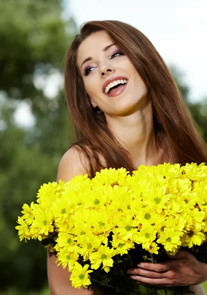 Genç bir kadın tutarak sarı çiçek — Stok fotoğraf