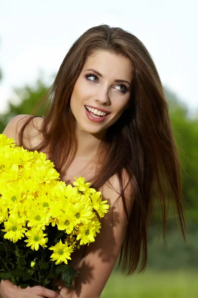 Mujer joven sosteniendo flores amarillas —  Fotos de Stock