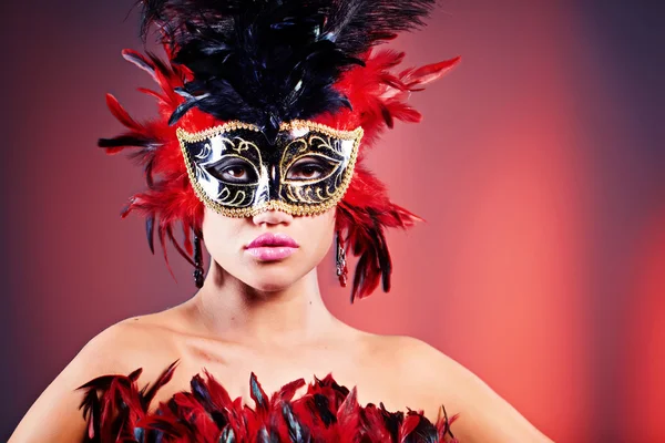 Güzel bir genç kadın karnaval maskesi ve tüylü boa. — Stok fotoğraf