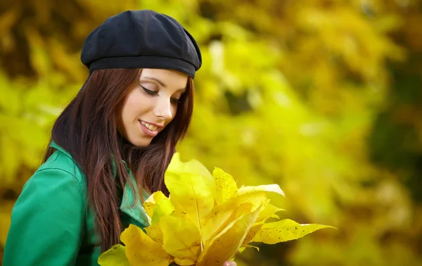 Fashion vrouw in de herfst park met geel blad — Stockfoto