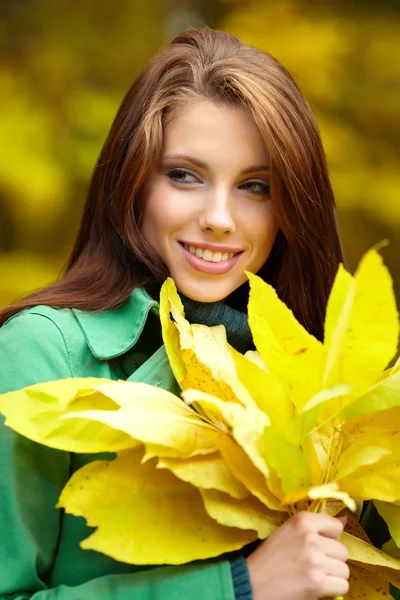 Sonbahar parkında sarı yaprak tutan moda kadını — Stok fotoğraf