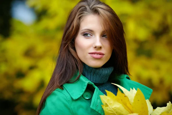 Μόδα γυναίκα στο πάρκο φθινόπωρο κρατώντας κίτρινο φύλλο — Φωτογραφία Αρχείου