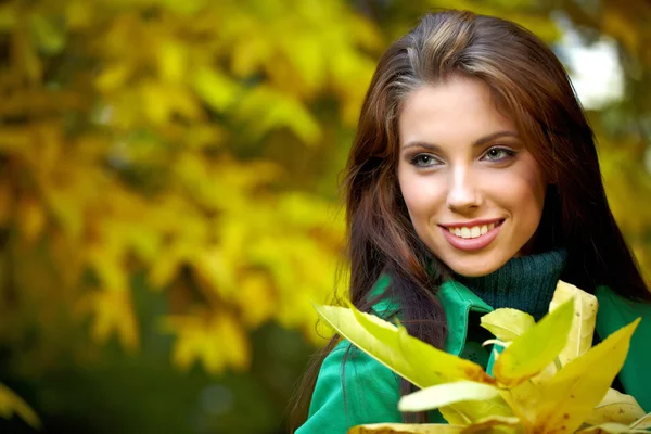 Fashion vrouw in de herfst park met geel blad — Stockfoto