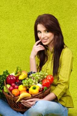 Portrait of a girl holding in hands full of different fruits and clipart