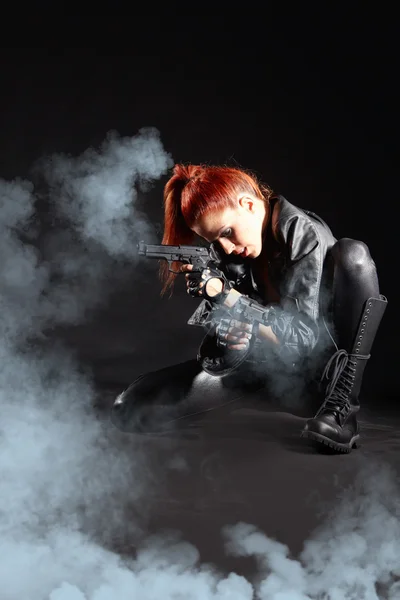 Bela menina sexy segurando arma. fundo de fumo — Fotografia de Stock