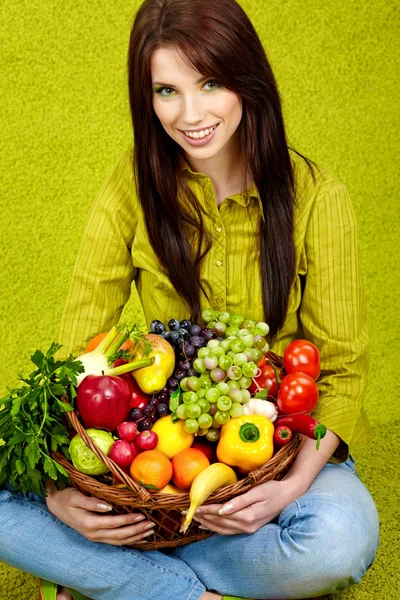 Retrato de una niña sosteniendo en las manos llenas de diferentes frutas y — Foto de Stock