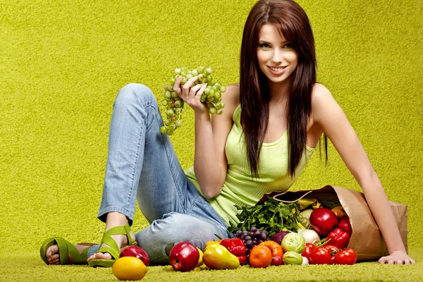 Porträtt av en flicka som håller i handen full av olika frukter och — Stockfoto