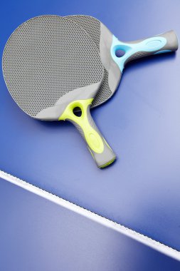 iki Masa Tenisi veya ping pong raketleri ve topları mavi bir tablo