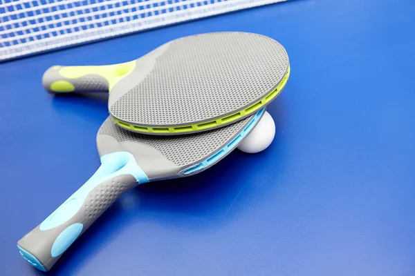 Two table tennis or ping pong rackets and balls on a blue table — Stock Photo, Image