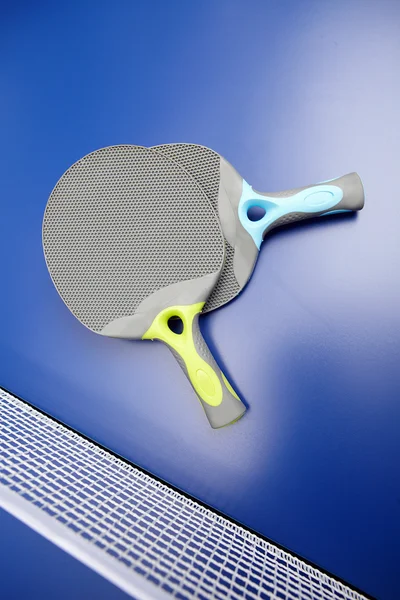 Два настільний теніс або ракетки для пінг-понг і м'ячі на синьому столі — стокове фото