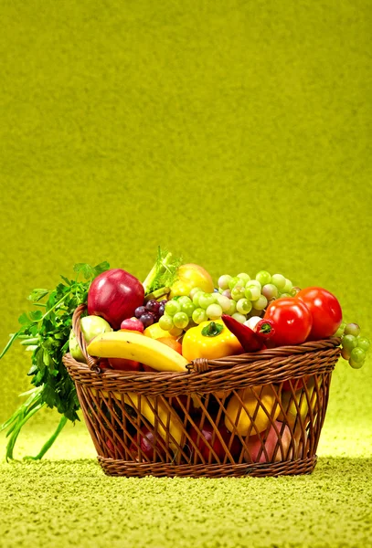 Cestino pieno di prodotti freschi. sfondo verde — Foto Stock
