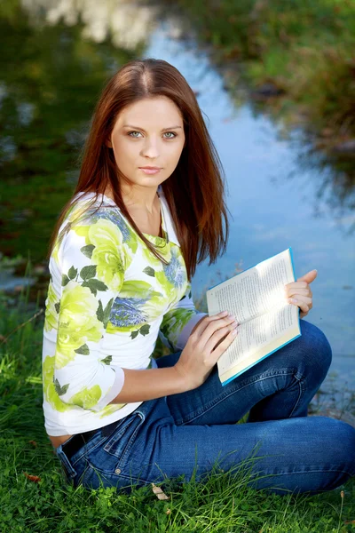 Młoda kobieta studia w lato park — Zdjęcie stockowe