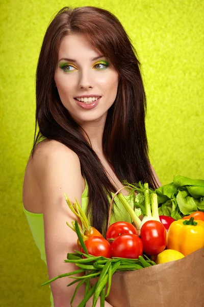 Portrait of a girl holding in hands full of different fruits and — Stock Photo, Image