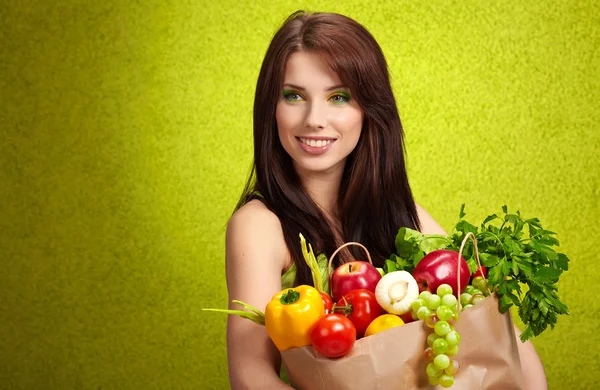Porträtt av en flicka som håller i handen full av olika frukter och — Stockfoto