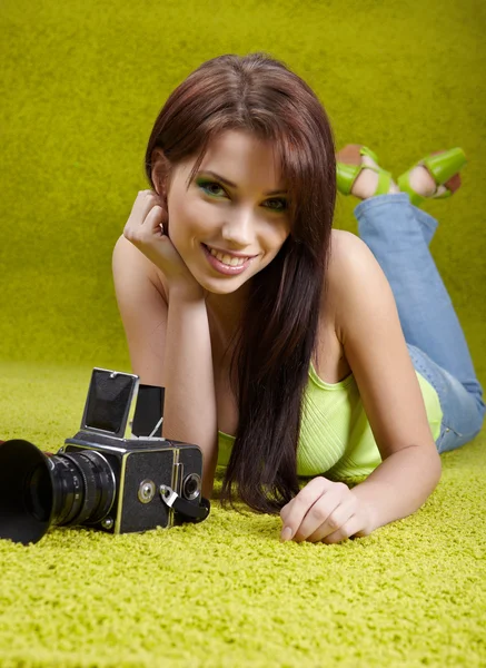 Vrouw met camera op groene lente achtergrond — Stockfoto