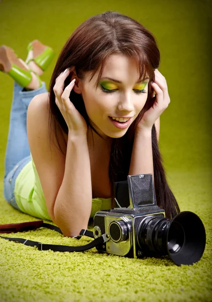 Vrouw met camera op groene lente achtergrond — Stockfoto
