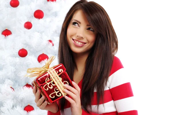Ajándékot fehér karácsonyfa mellett, a gyönyörű nő — Stock Fotó