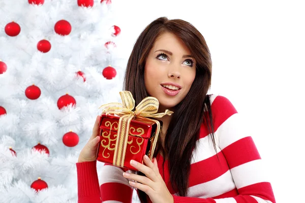 Mooie vrouw met cadeau naast witte kerstboom — Stockfoto