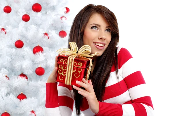 Beautiful woman with gift next to white christmas tree — Stock Photo, Image