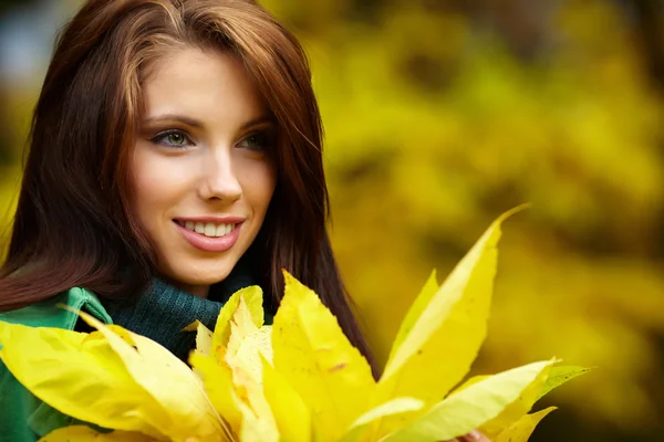 Femme de mode dans le parc d'automne tenant feuille jaune — Photo