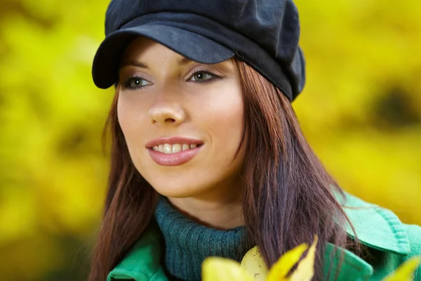 Modefrau im Herbstpark mit gelbem Blatt — Stockfoto
