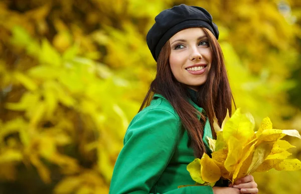 Donna di moda nel parco autunnale con foglia gialla — Foto Stock