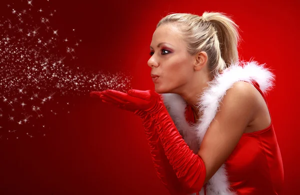Attraktive sexy Mädchen in Weihnachtsmann Tuch weht Schnee aus den Händen. — Stockfoto